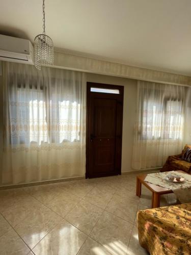 a living room with a couch and a door at LEONORA’S APARTMENT in Prinos