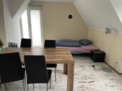 ein Esszimmer mit einem Tisch, Stühlen und einem Bett in der Unterkunft Ferienwohnung Sprockhövel in Sprockhövel