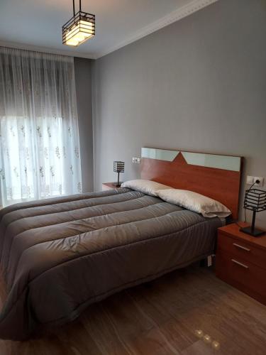 a bedroom with a large bed and a window at Apartamento La Muralla in Baena