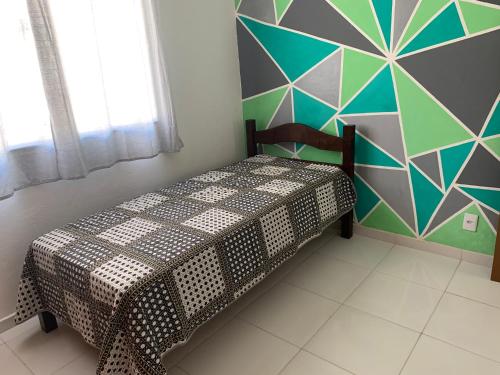 a bedroom with a bed with a geometric wall at Lindo Loft completo perto de cachoeira in Guapimirim