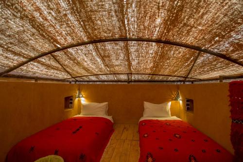 two beds in a room with a ceiling at Terres d'Amanar in Tahannout