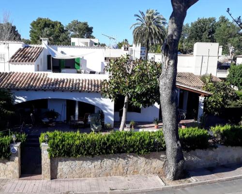 ein Haus mit einem Baum davor in der Unterkunft Casa Tritons in Port d'Alcúdia