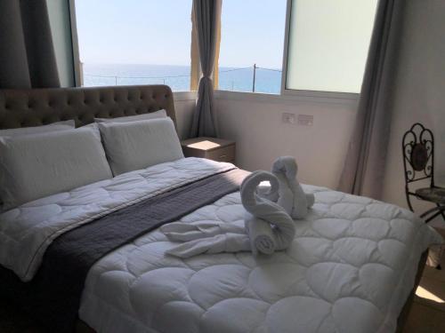 een slaapkamer met een bed met een handdoekendier erop bij Hotel Room Service in Bat Yam