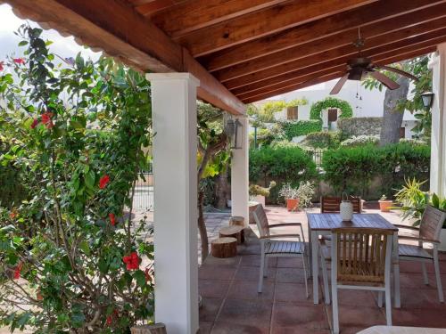 a patio with a table and chairs under a wooden pergola at Casa Tritons in Port d'Alcudia