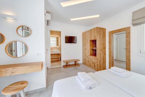 a bedroom with two beds and a mirror at Makis Place in Tourlos