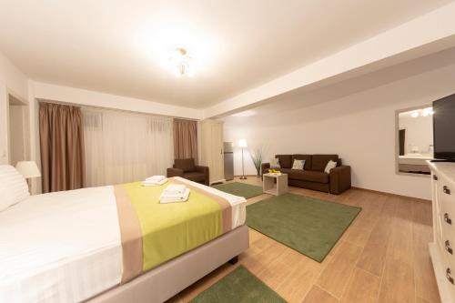 Habitación de hotel con cama y sofá en Crema Residence, en Alba Iulia