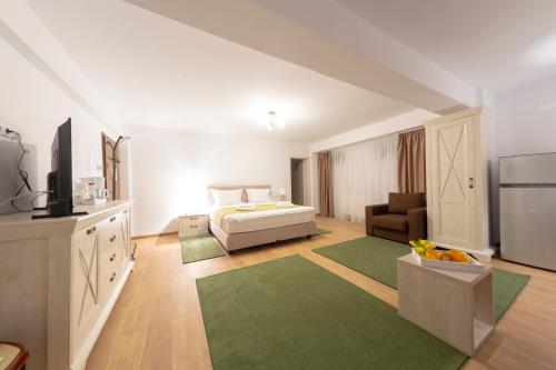 a white bedroom with a bed and a couch at Crema Residence in Alba Iulia