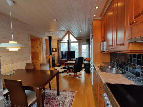 eine Küche und ein Wohnzimmer mit einem Tisch und einem Esszimmer in der Unterkunft Panorama Blue Apartments in Kilpisjärvi