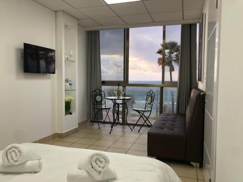 a hotel room with a bed and a view of the ocean at Sea Line Hotel From R&A Group in Bat Yam