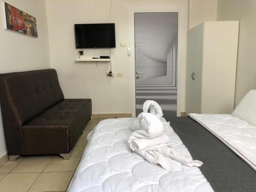 a room with a bed with a towel animal on it at Sea Line Hotel From R&A Group in Bat Yam