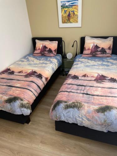 two beds sitting next to each other in a room at Genieten in een luxe vakantiewoning, dichtbij het IJsselmeer en strand in Warns