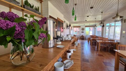 un restaurante con una larga mesa de madera con flores púrpuras en Domki Sonar, en Bobolin