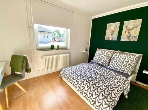 een slaapkamer met een bed en een groene muur bij Die Zeitwohnung in Hochheim am Main