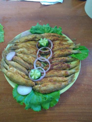 a pita sandwich with onions and lettuce on a table at Guesthouse Mirabela in Shekvetili
