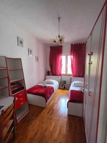 - une chambre avec 2 lits et des rideaux roses dans l'établissement Apartman Nada, à Sali