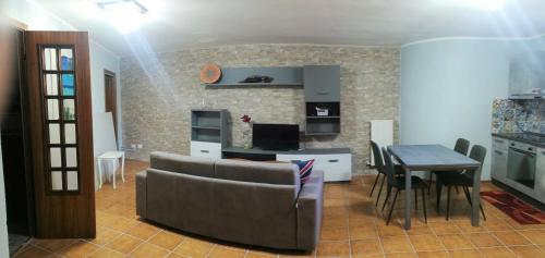 ein Wohnzimmer mit einem Sofa und einem Tisch in der Unterkunft La Taverna Appartamento Scala a Chiocciola in Follonica