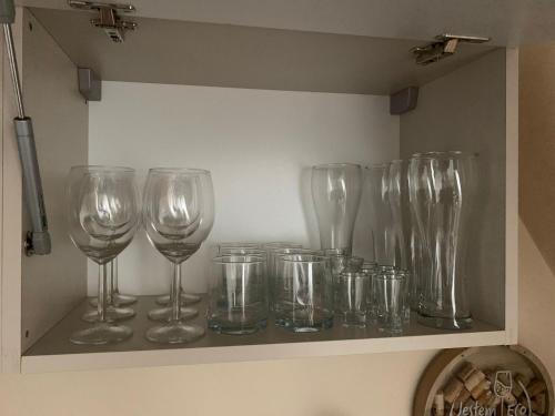 a row of wine glasses sitting on a shelf at Apartament Żeglarski Vęgoria Deluxe z widokiem na Port in Węgorzewo