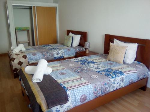 una camera da letto con due letti con asciugamani sopra di Casa Central a Ponta Delgada