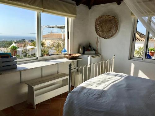 a bedroom with a bed and a large window at Casa da Aldeia in Santa Bárbara de Nexe