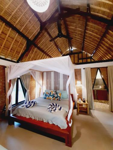 a bedroom with a bed with a canopy at JEJU Cottages in Kuta Lombok