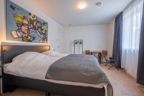 um quarto com uma cama com um quadro na parede em Bed & Parking Burght van Texel em Den Burg