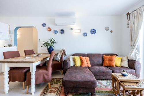 sala de estar con sofá y mesa en Serenidade - sunny flat in the centre of Salema, en Salema