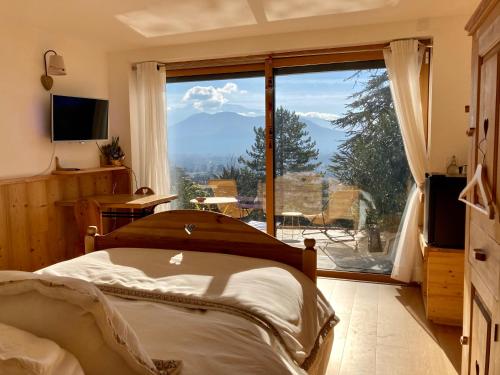 a bedroom with a bed and a large window at Chambre Belledonne in La Tronche