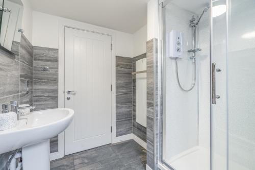 a white bathroom with a shower and a sink at Charming Apartment In Andover Town Centre 55'' 4K Smart TV Netflix in Andover