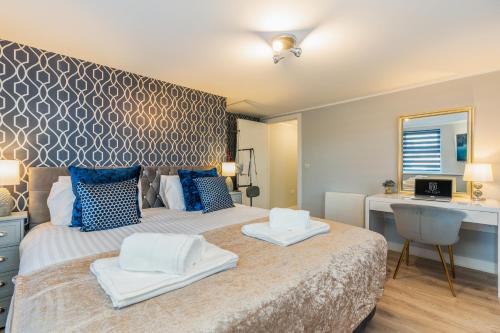 a bedroom with a bed with blue and white pillows at Charming Apartment In Andover Town Centre 55'' 4K Smart TV Netflix in Andover