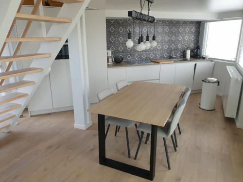 a kitchen and dining room with a wooden table and chairs at Duinengolf 5 in Middelkerke