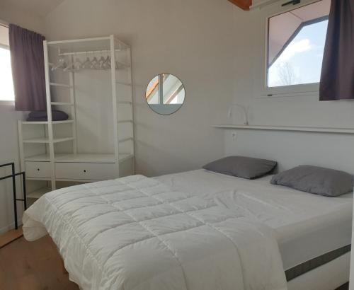 a bedroom with a large white bed and a window at Duinengolf 5 in Middelkerke