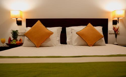 a bedroom with a bed with orange and white pillows at Nature Trails Boutique Hotel in Unawatuna