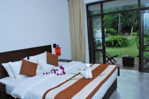 a bedroom with a large bed with flowers on it at Nature Trails Boutique Hotel in Unawatuna