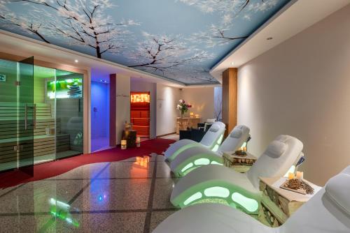 a waiting room with white chairs and a ceiling with trees at Hotel Europa in San Martino di Castrozza