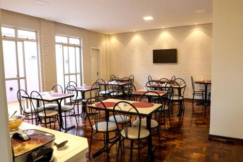 a room with tables and chairs and a flat screen tv at Novo Hotel Iguaçu in Pôrto União