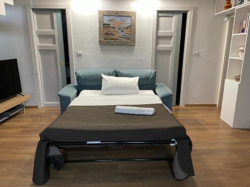 een bed in een kamer met een blauwe bank bij donna serena Aci Castello in Aci Castello