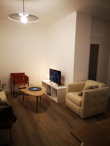 エピナルにあるSO HOME EPINAL - Belle-Riveのソファとテレビのあるリビングルーム