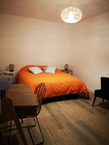 エピナルにあるSO HOME EPINAL - Belle-Riveのオレンジ色の毛布が掛けられたベッドのある寝室