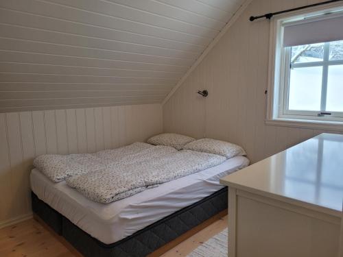 a small bed in a room with a window at Flohytta in Stryn