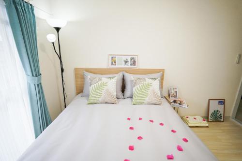 Un dormitorio con una cama con corazones rosados. en stay's サンジョイフル 303号 名古屋 民泊 駅近 en Nagoya