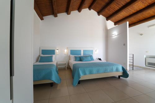a bedroom with two beds with blue and white at Life Hotels Kalaonda Resort in Siracusa