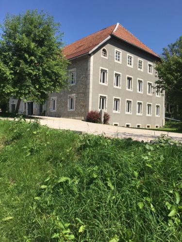 a large stone building with a tree in front of it at Domaine de Malpas in Villers-le-Lac