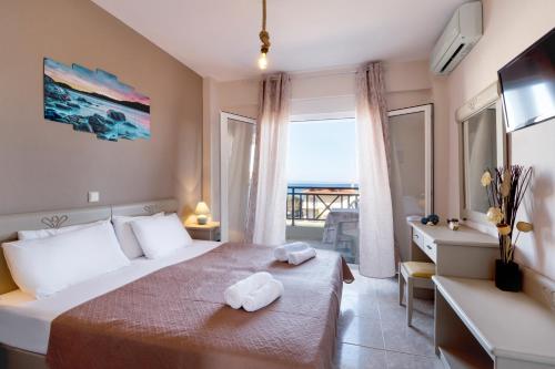 Una habitación de hotel con una cama con toallas. en Sueño beach hotel, en Polychrono
