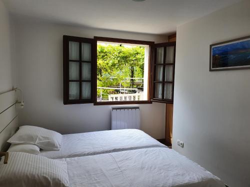 a bedroom with two beds and a window at 3 Allée de l'Orée du Lac in Biarritz