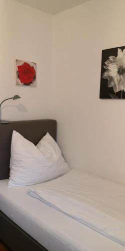 a bed with a white pillow and a picture on the wall at Zimmervermietung Stocker in Waidhofen an der Ybbs