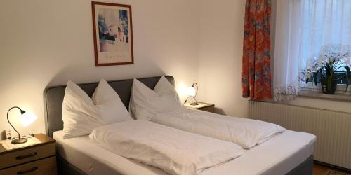 a bedroom with a bed with white sheets and pillows at Zimmervermietung Stocker in Waidhofen an der Ybbs