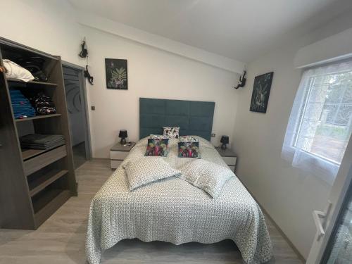 a bedroom with a bed with a white comforter at Le Miroir in Domérat
