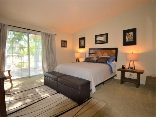 a bedroom with a bed and a large window at MESQUITE ZEN RETREAT in Palm Springs