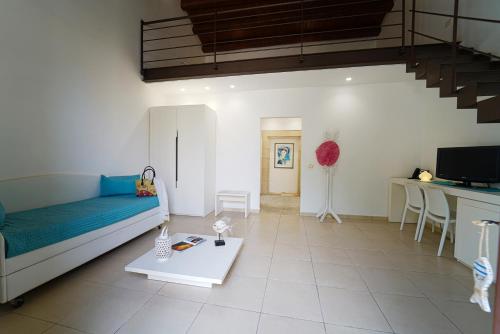 a living room with a blue couch and a table at Life Hotels Kalaonda Resort in Siracusa