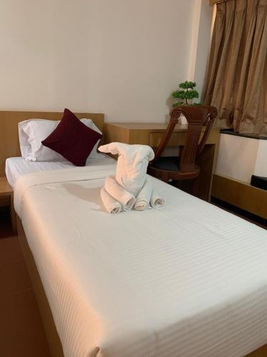 a towel animal is sitting on a bed at Hotel Kewal in Nashik